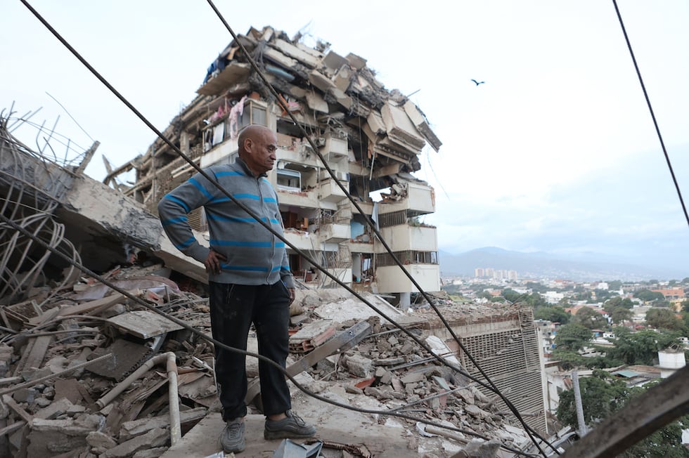 Un hombre permanece de pie entre los escombros de un edificio derrumbado tras un terremoto en...